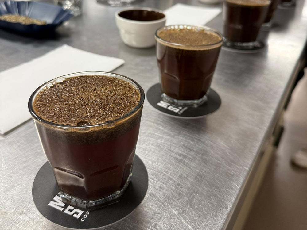 Vaso de cata con la costra de café sobre la mesa de cata